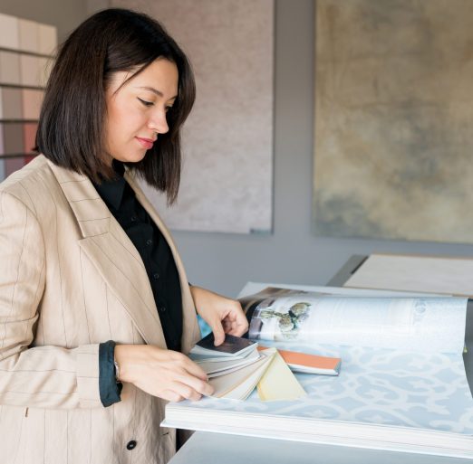 Design and Consultation Services: Woman analyzing color palettes for interior painting by AC Reformas.