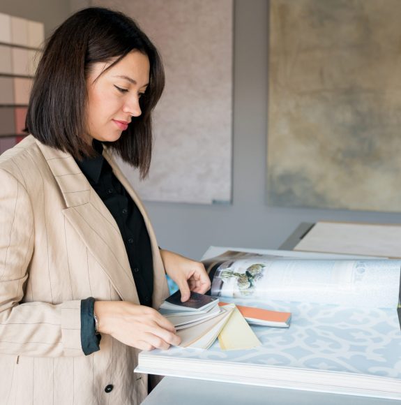 Design and Consultation Services: Woman analyzing color palettes for interior painting by AC Reformas.