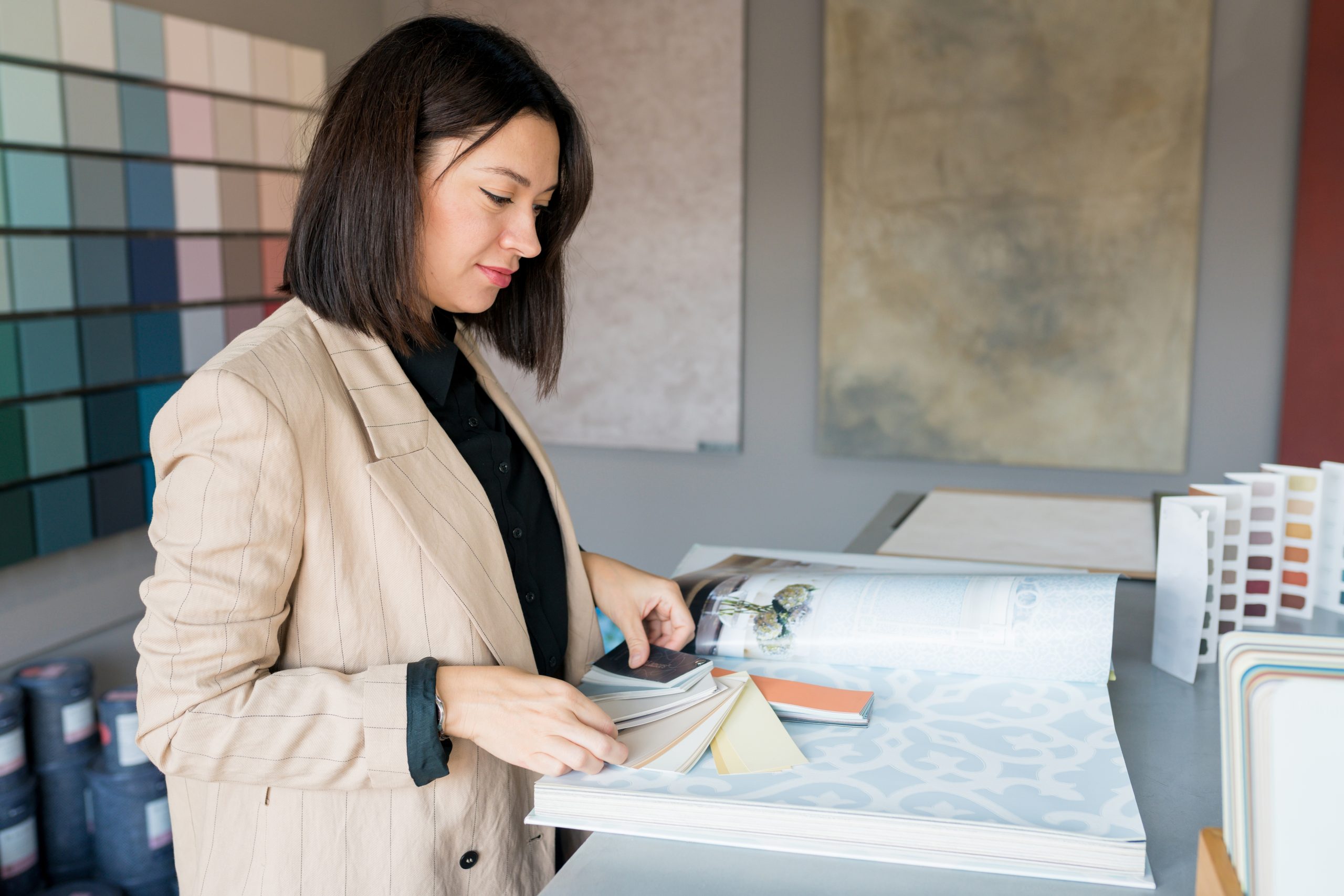 Design and Consultation Services: Woman analyzing color palettes for interior painting by AC Reformas.